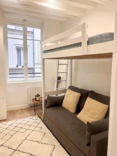 - un salon avec un canapé et des lits superposés dans l'établissement Studio Annah, à Paris