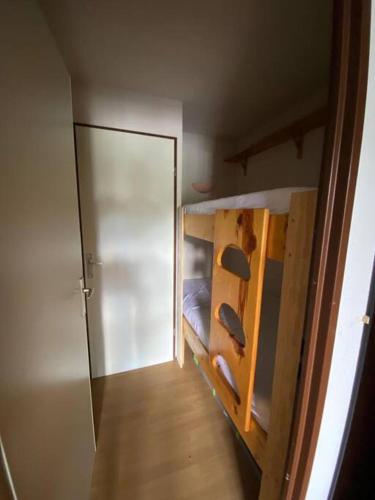 Cette petite chambre comprend des lits superposés et une porte. dans l'établissement Studio au pied des pistes., à Ax-les-Thermes