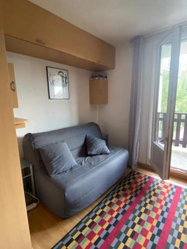 ein Sofa im Wohnzimmer mit Fenster in der Unterkunft Studio au pied des pistes. in Ax-les-Thermes