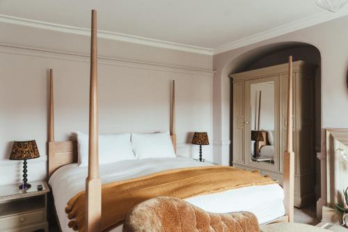 a bedroom with a large bed with a wooden frame at The Falcon Inn in Painswick