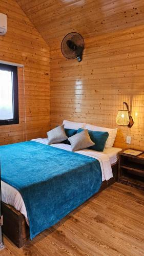 a bedroom with a large bed in a wooden room at Winhouse Villa in Hoi An