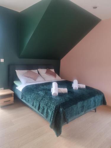 a bedroom with a green bed with two pillows at ZuMiLu House in Zagórz