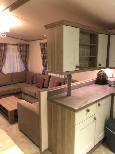 a kitchen and a living room with a couch at Lovely Caravan in Turnberry