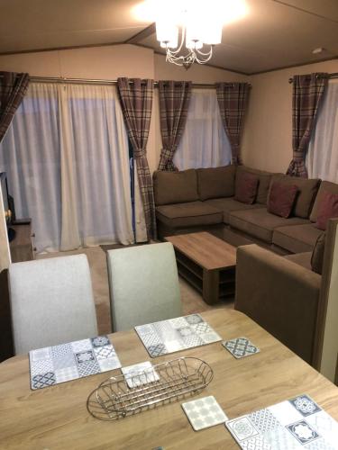 a living room with a table and a couch at Lovely Caravan in Turnberry