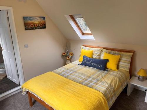 a bedroom with a bed with yellow and blue pillows at Colne Brook Barn in Alvington