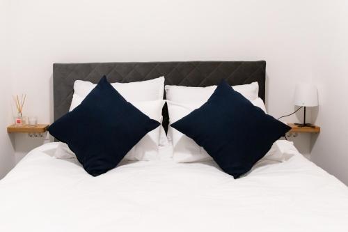 a bed with black and white pillows on it at Oliver street apartment Vipava in Vipava