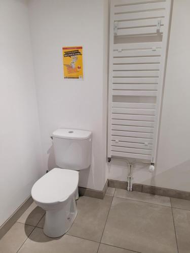 un bagno con un water bianco e una persiana di L'apaisant a Houlgate