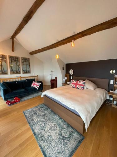 une chambre avec un grand lit et un canapé dans l'établissement Large house near Paris, ideal OG, à Colombes