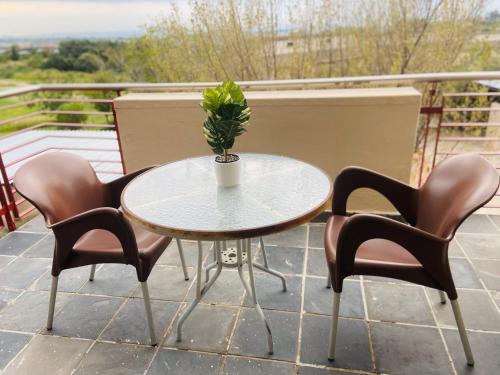 a table with chairs and a plant on a balcony at 82 St Andrews Jackal Creek Golf Estate with Backup power & Golf course views in Roodepoort