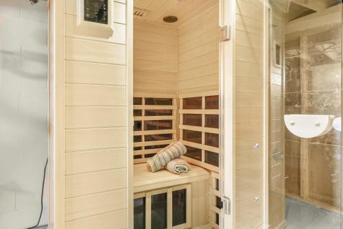 una sauna con paredes de madera y una puerta de cristal en NEW Urban Comfort On Grant St, en Lake Geneva