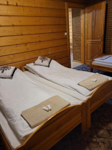 Duas camas num quarto de madeira com toalhas em Apartament Harenda em Zakopane