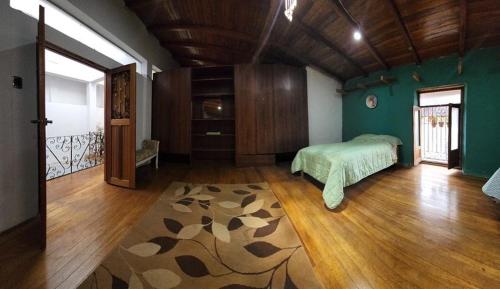 a bedroom with a bed and a rug on a wooden floor at Amplia y Céntrica Habitación - H. El Casero in Cajamarca