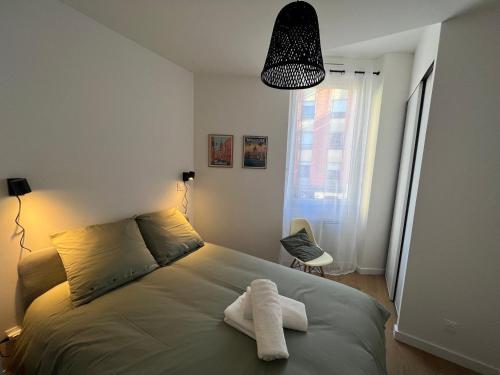 - une chambre avec un lit et 2 serviettes dans l'établissement Magnifique T2 - proche hyper centre, à Toulouse