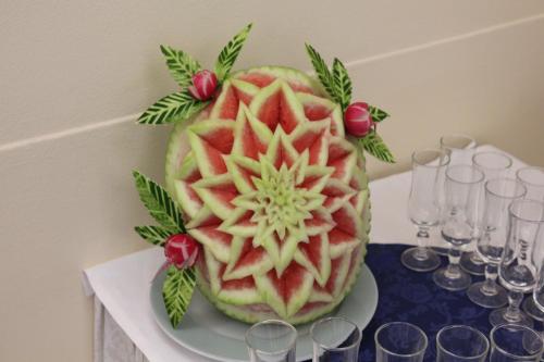a watermelon cake on a plate on a table with wine glasses at Terme Villa Pace in Abano Terme