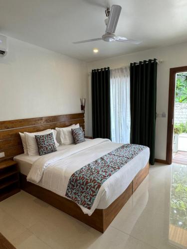 1 dormitorio con 1 cama grande y cortinas negras en Akiri Dhigurah en Dhigurah