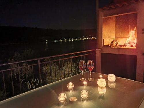 una mesa con 2 copas de vino y una chimenea en Holiday Home Villa Marela, en Veliki Drvenik