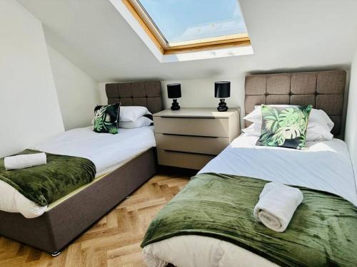 a bedroom with two beds and a window at Social Central - No 1 for large groups in Cardiff