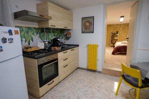 a kitchen with a stove and a refrigerator and a bedroom at Al Vicolo in Enna