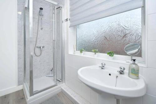 a white bathroom with a sink and a shower at Croft House - By Sigma Stays in Crewe