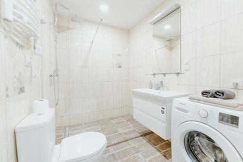 a white bathroom with a washing machine in it at New Modern studio apartment next to the city centre in Vilnius