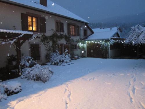 a house with christmas lights in the snow at Gîte des Grands Clos in Saint-Amé