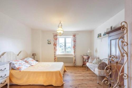 1 dormitorio con 1 cama y 1 sofá en Gîte des Grands Clos, en Saint-Amé