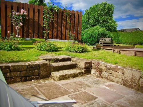 a garden with a fence and some stairs in the grass at Gîte des Grands Clos in Saint-Amé
