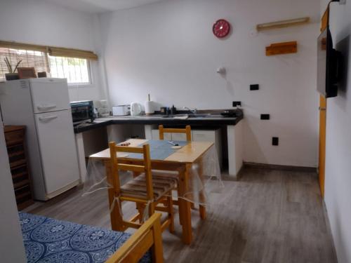 a kitchen with a table and chairs and a refrigerator at Monoambiente Villa Crespo in Buenos Aires