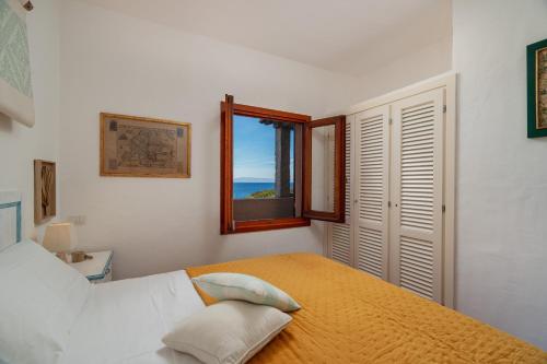 a bedroom with a large bed with a window at Sunset Home in Costa Paradiso