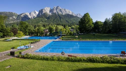a large swimming pool with mountains in the background at Ferienwohnung Bergspitz in Grainau
