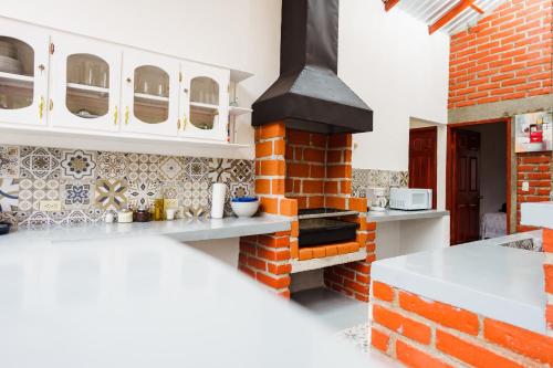 uma cozinha com um forno de tijolos num quarto em Entre Pinos em Comayagua