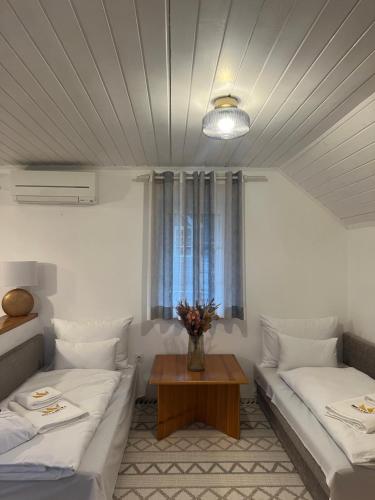 Sala de estar con 2 camas y mesa en Bella Mura Nature Apartment Lipa 97 en Podčetrtek