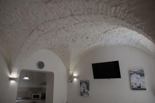 Una habitación con un techo con un televisor encima. en Conte Ugolino 71, en Martina Franca