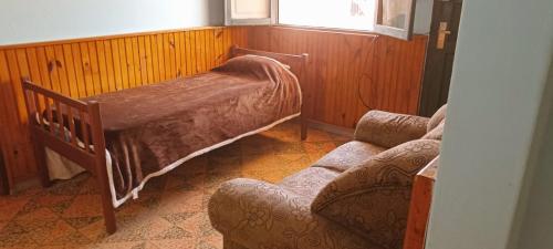 a room with a bed and a couch and a window at Doña beba in Artigas