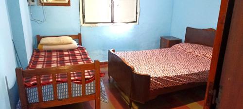 a small room with two beds and a window at Doña beba in Artigas