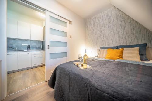 ein Schlafzimmer mit großem Bett und eine Küche in der Unterkunft La Vida apartman Hajdúszoboszló in Hajdúszoboszló