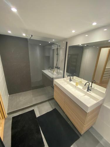 une salle de bain avec deux lavabos et deux miroirs dans l'établissement Maison Bollène, à Bollène