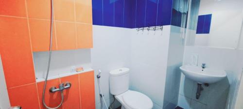 a bathroom with a toilet and a sink at Tos Residence in Tangerang
