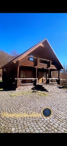a large wooden building with a large circle in front of it at Moonglade Allure Houses in Polyana