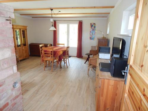 a living room with a table and a dining room at Ferienhaus am Wald mit Klavier, Holzofen, Sauna in Alt Jabel
