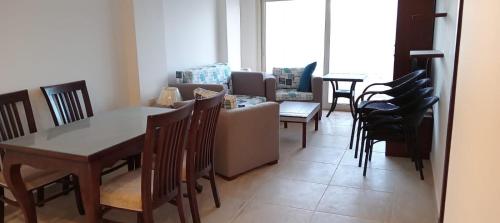 een woonkamer met een tafel en stoelen bij Oyster bay beach resort in Marsa Alam