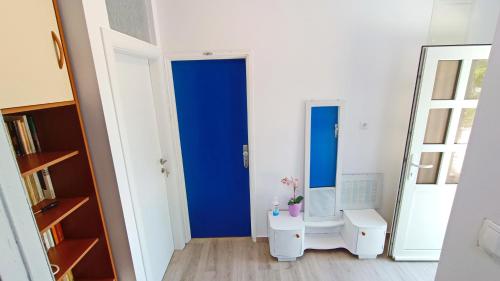 una camera con una porta blu e uno specchio di Vesna - room with private bathroom near sea a Trogir