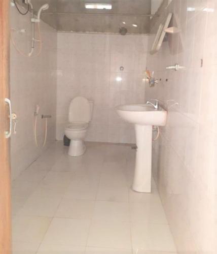 a bathroom with a toilet and a sink at Talpe Inn in Unawatuna