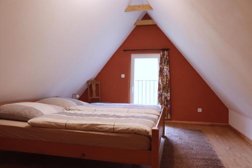 a attic bedroom with two beds and a window at Ferienhaus am Wald mit Klavier, Holzofen, Sauna in Alt Jabel