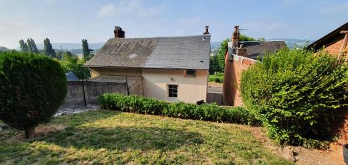 een oud huis met een grijs dak en een tuin bij Maison de ville in Pont-Audemer