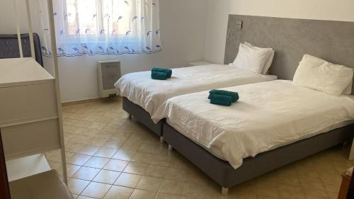 Dos camas en un dormitorio con toallas verdes. en Terra da Eira - Villa mit Pool Western Algarve, en Vila do Bispo