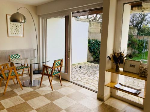 een eetkamer met een tafel en stoelen en een glazen deur bij Piriac, maison familiale, accès direct plage, 12 couchages in Piriac-sur-Mer