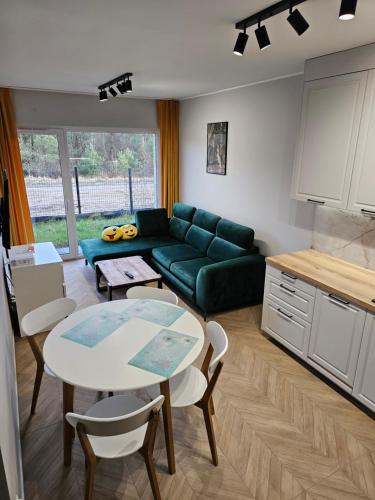 a living room with a green couch and a table at Apartament Konstancji in Piła