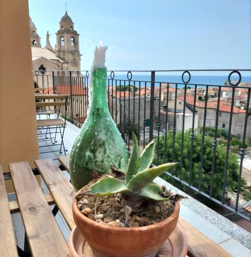 a green bottle sitting on a wooden table with a plant at A Carubba du Bungiurnu in Borgio Verezzi