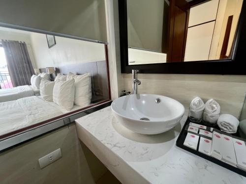 a bathroom with a sink and a large mirror at Paragon House and Residence in Hanoi